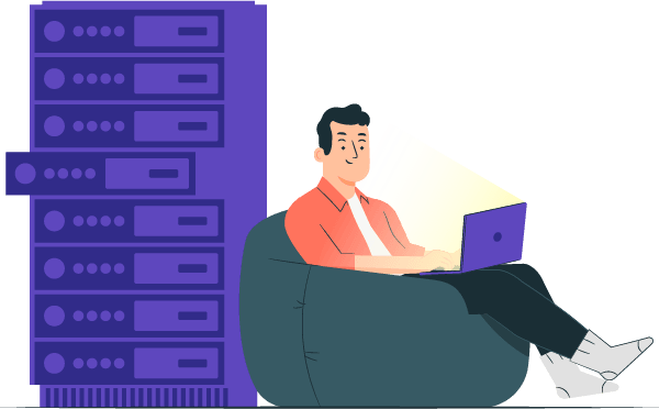 A man sitting comfortably with a laptop beside a large server.