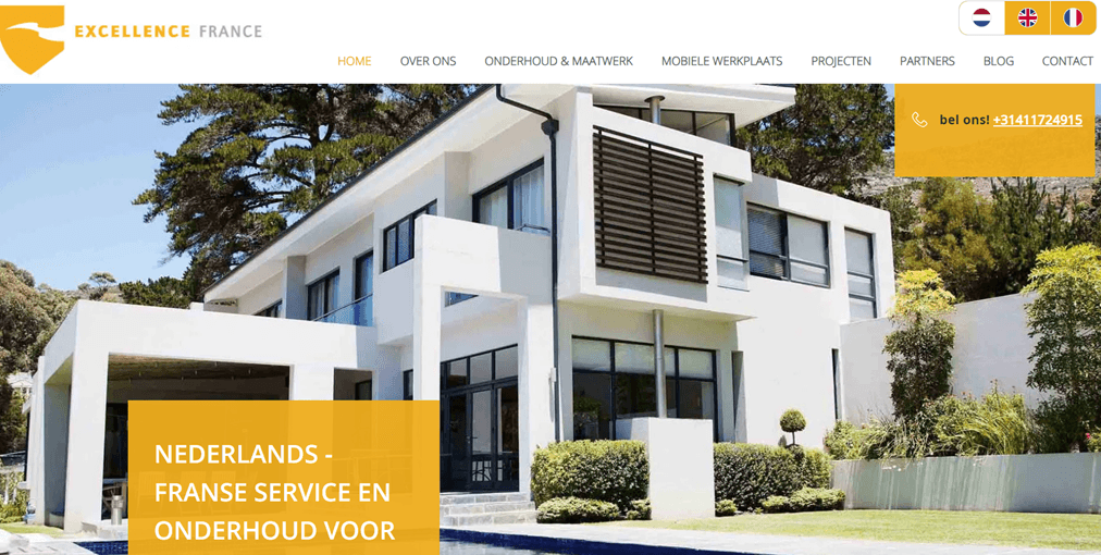 A modern house with large windows and trees in the background. The house has a sleek design.