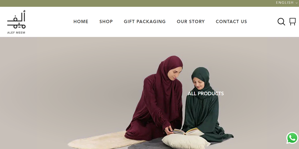 Two Muslim women wearing hijab and abaya sitting on mat