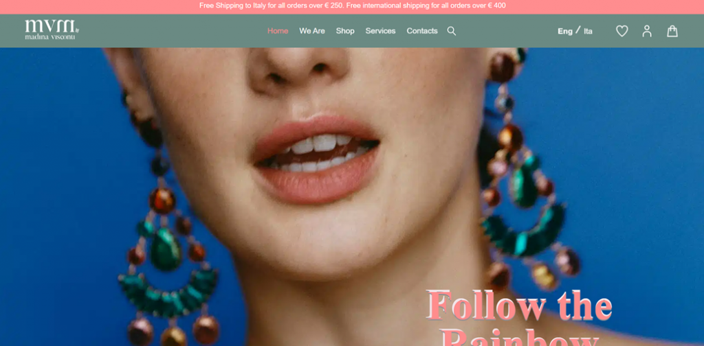 Close-up of a woman's face with vibrant earrings. She has a subtle expression.