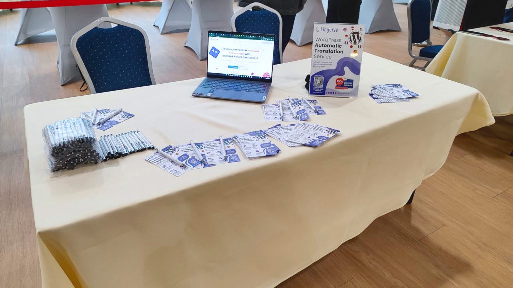 A table with a laptop and various promotional items
