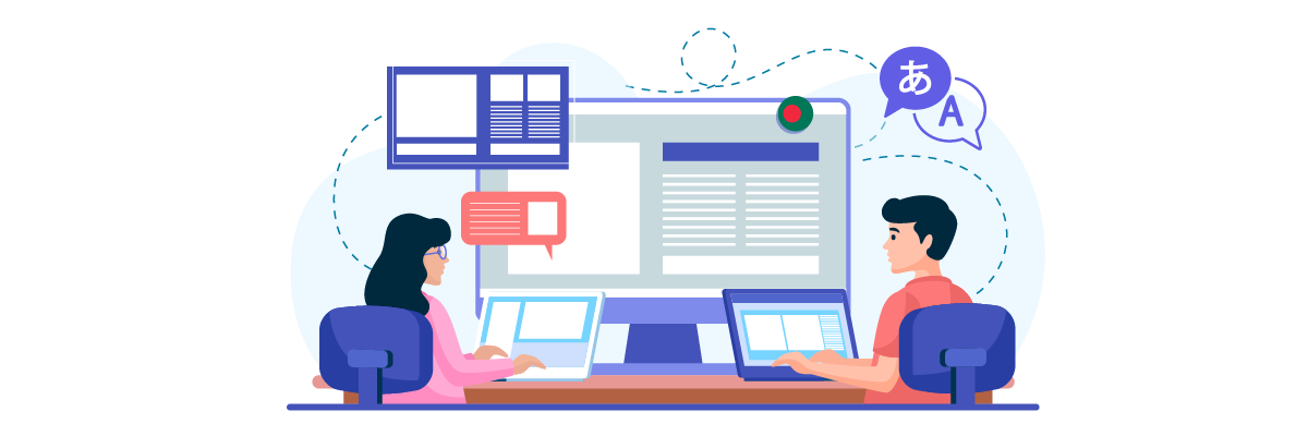 Two people sitting at a desk with multiple computers and screens. They appear to be collaborating.